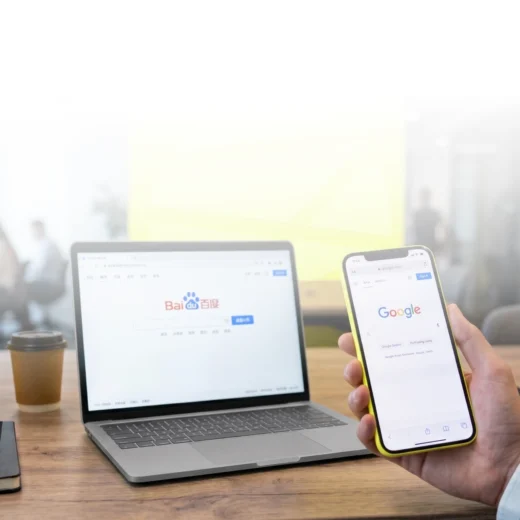a phone and a laptop respectively showing the homepage for google and baidu
